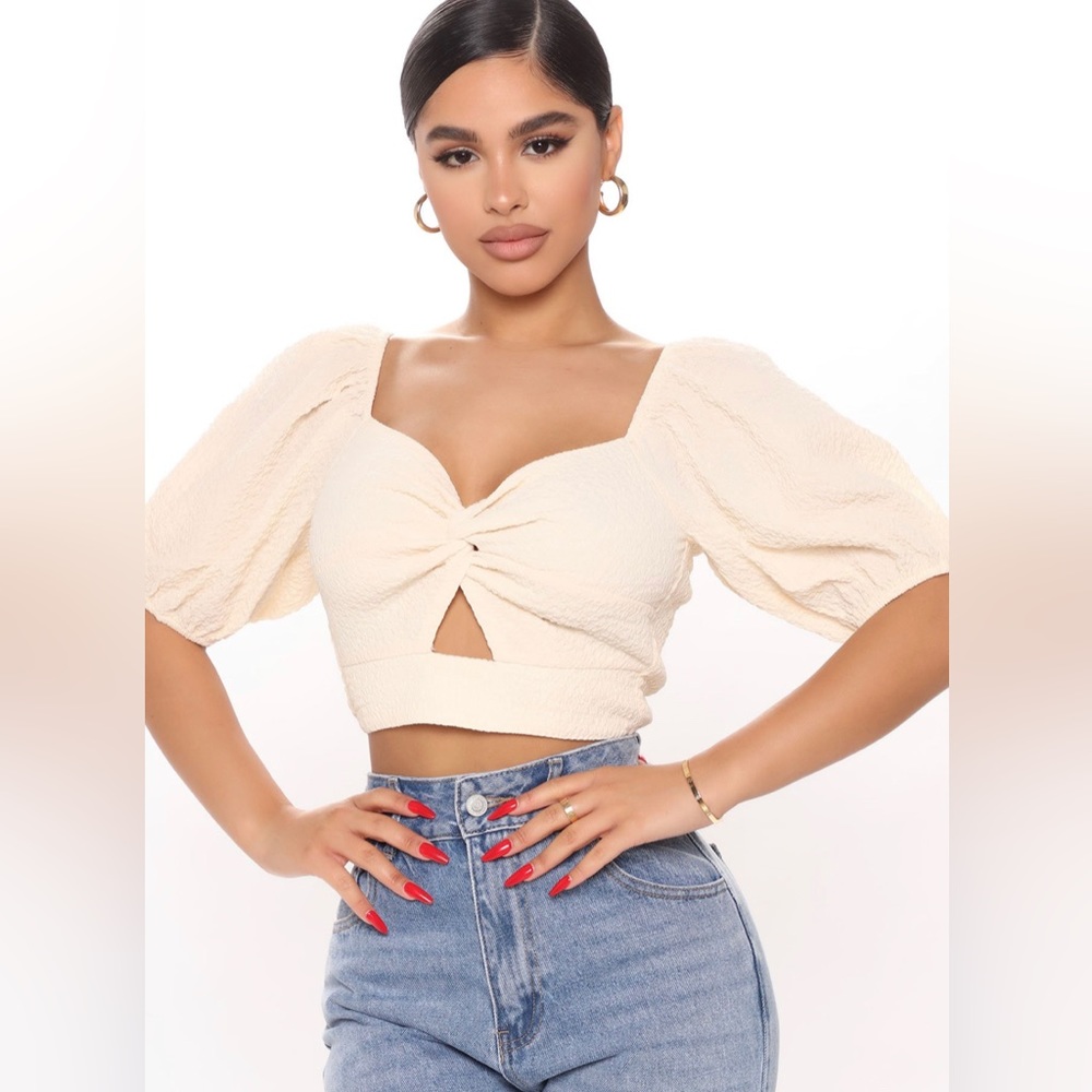 Beige crop top with puffy sleeves and twist on front size small.